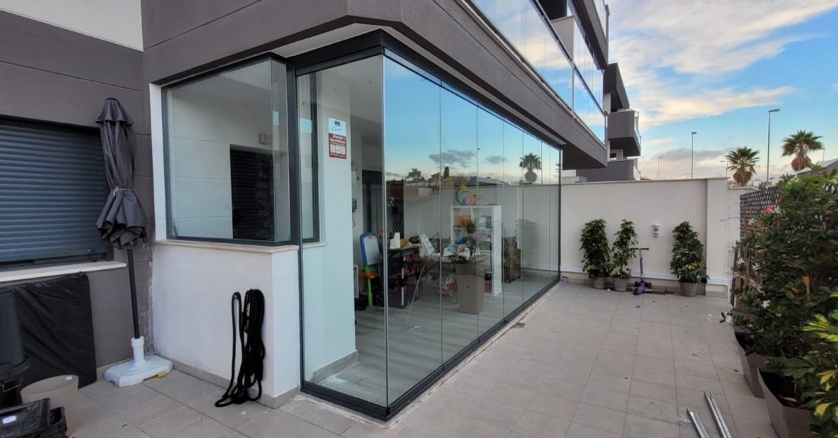 Cortina de cristal sin perfiles verticales cerrando una terraza en Málaga